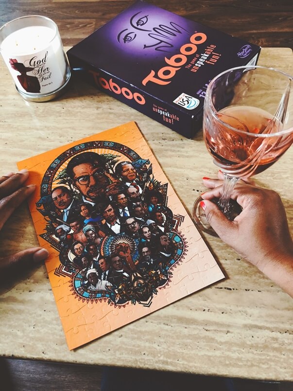 black image puzzle, brown hands holding a glass of wine