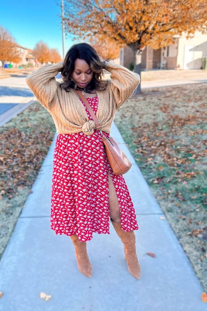 plus size black woman wearing red floral dress, brown cardigan, and brown suede boots for early spring